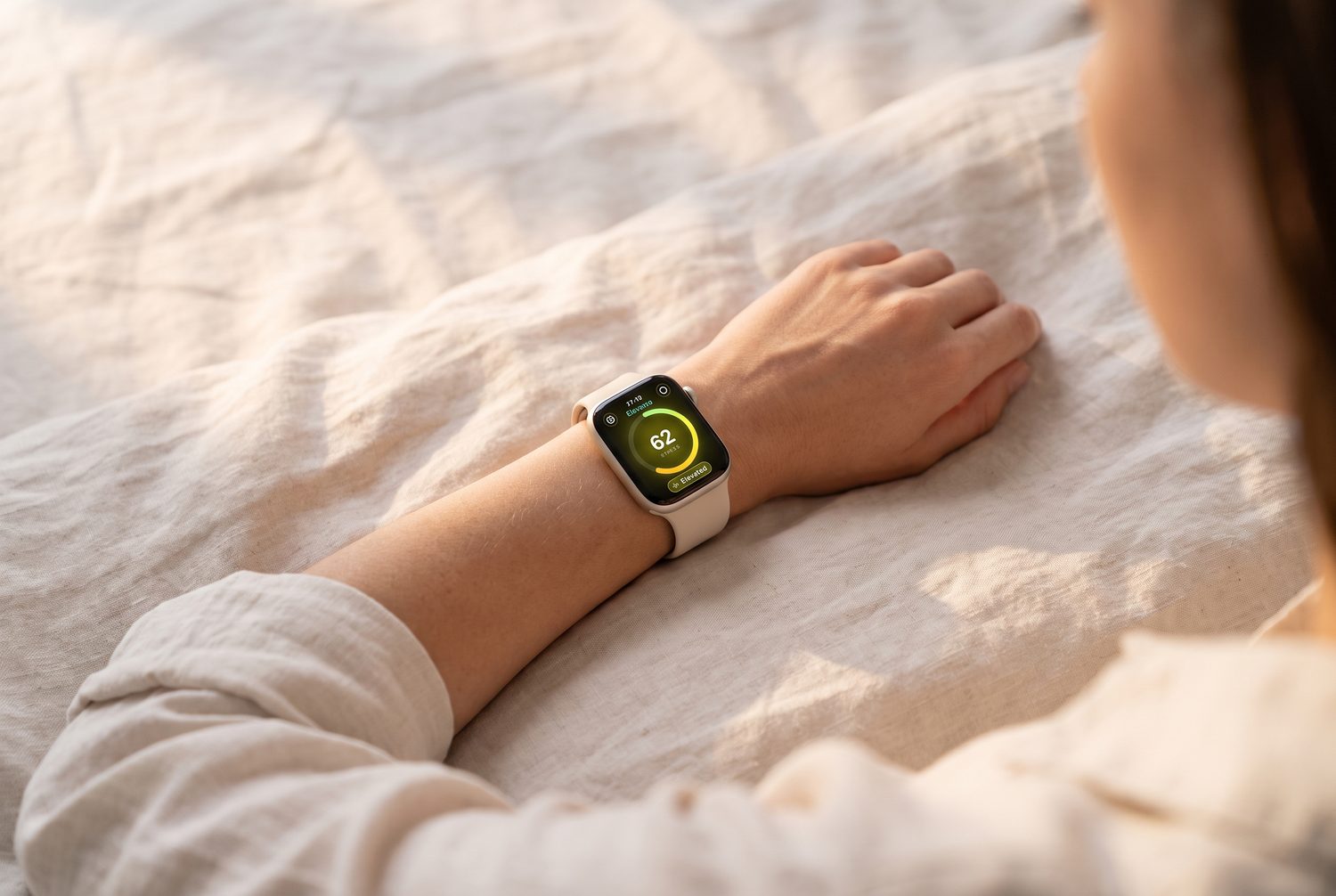 A wrist wearing Calmline resting on bedding in morning light